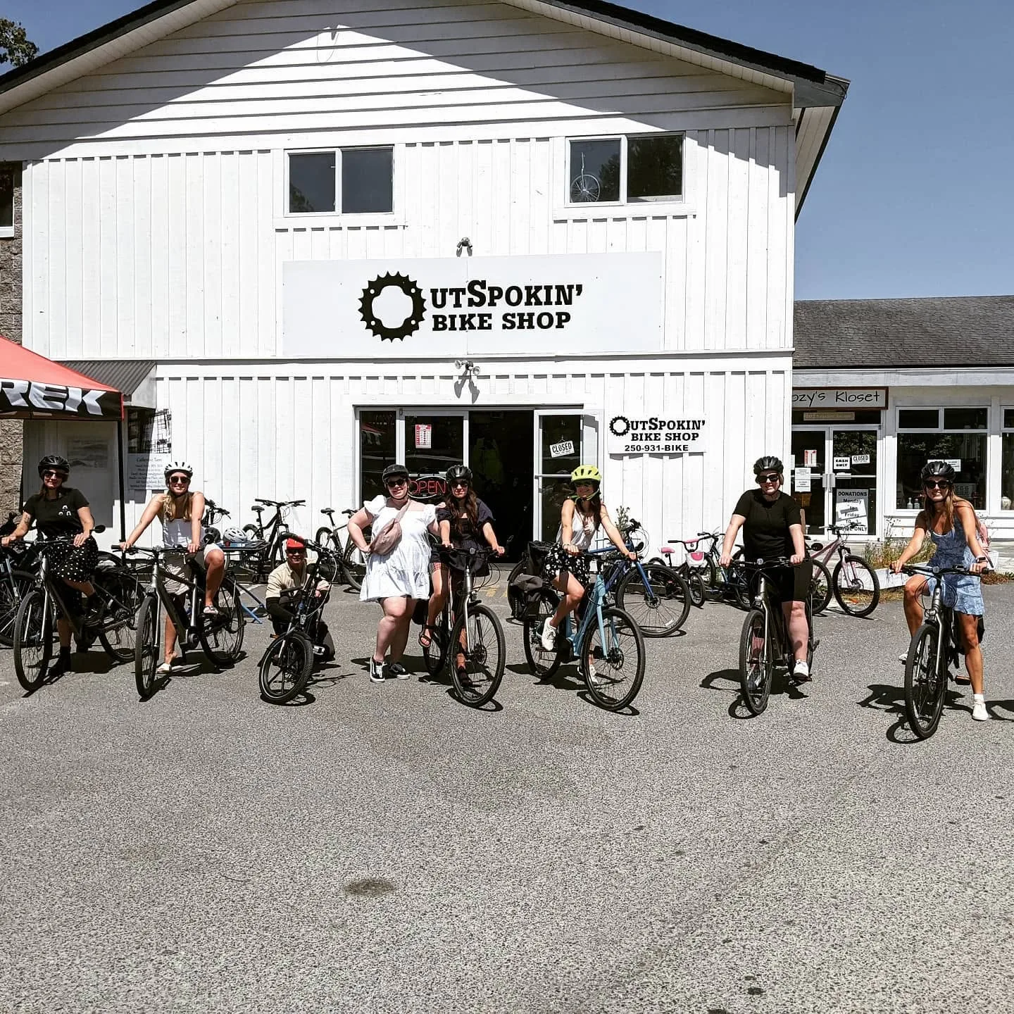 OutSpokin' Bike Shop with happy customers on bikes